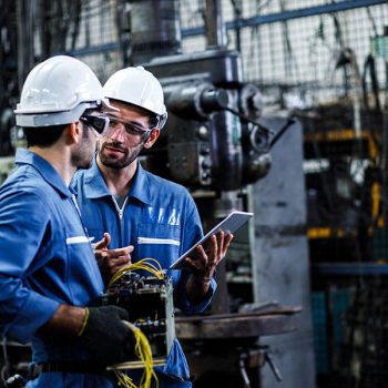 Two men engineer talking in modern factory. Production line mach Two men engineer talking in modern factory. Production line mach